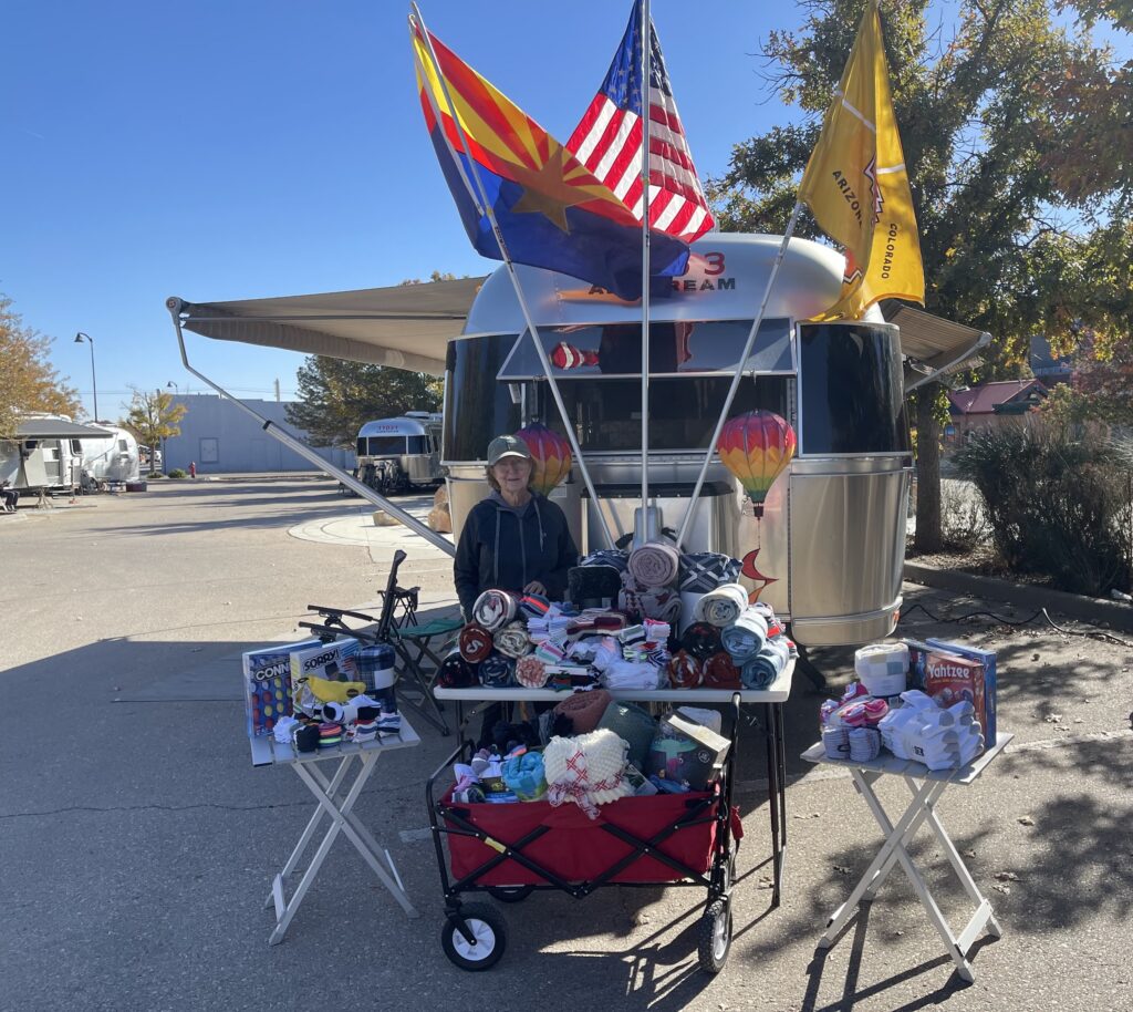 Donations collected from Airstream Club members for Packs of Love during an Airstream Club Rally in Artesia, New Mexico. Airstreams in the background.