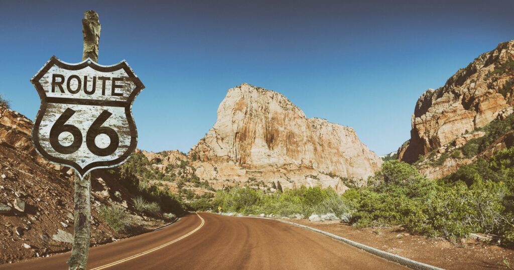 Route 66 sign and majestic road trip scenery to advertise an airstream caravan in New Mexico and Arizona